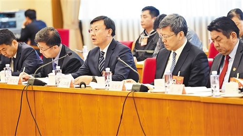 上图 3月12日，人大内蒙古代表团举行全体会议。全国人大代表、内蒙古自治区包头市市长赵江涛(中)表示，生态文明建设利国利民。 本报记者 李景录摄