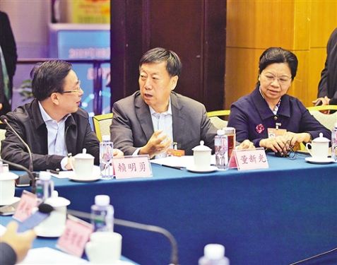 左图 3月10日，全国政协民建界别在驻地举行小组会议。会前，全国政协委员蒙晓灵、董新光、赖明勇(从右至左)就“如何探索生态优先、绿色发展为导向的新路子”展开交流。 本报记者 高兴贵摄